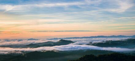 Mountain fog valley during sunrise.The background of nature with fog on the mountain, In the rainy weather in the countryside photo