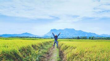 Asian man travel relax in the holiday. Jump natural touch mountain field. Jump stand glad middle field rice. Thailand photo