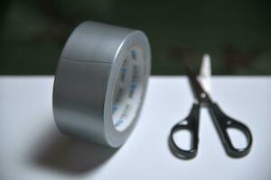 Grey adhesive tape and scissors on the table photo