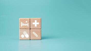 Wooden blocks with medical symbol icons on blue background representing health concept with treatment and medicine. photo
