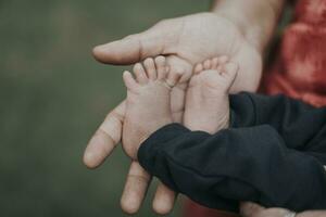 Little baby feet in mother's hands photo