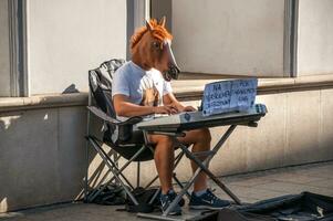 Warsaw, Poland- Oct 1, 2016 - Guy in horse mask playing piano photo