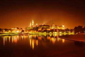 Night view on the ancient castle over the river photo