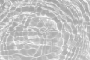 White water with ripples on the surface. Defocus blurred transparent white colored clear calm water surface texture with splashes and bubbles. Water waves with shining pattern texture background. photo