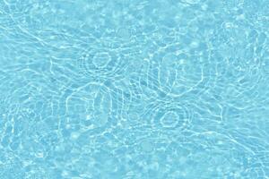 Blue water with ripples on the surface. Defocus blurred transparent white-black colored clear calm water surface texture with splash and bubbles. Water waves with shining pattern texture background. photo