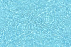 Blue water with ripples on the surface. Defocus blurred transparent white-black colored clear calm water surface texture with splash and bubbles. Water waves with shining pattern texture background. photo