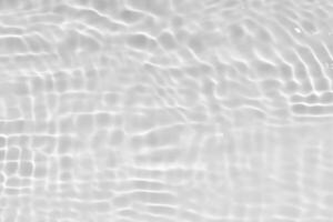 White water with ripples on the surface. Defocus blurred transparent white colored clear calm water surface texture with splashes and bubbles. Water waves with shining pattern texture background. photo