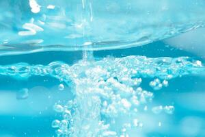 Blue water with ripples on the surface. Defocus blurred transparent white-black colored clear calm water surface texture with splash and bubbles. Water waves with shining pattern texture background. photo