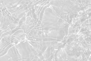 White water with ripples on the surface. Defocus blurred transparent white colored clear calm water surface texture with splashes and bubbles. Water waves with shining pattern texture background. photo