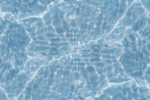 Defocus blurred transparent blue colored clear calm water surface texture with splashes reflection. Trendy abstract nature background. Water waves in sunlight with copy space. Blue watercolor shine. photo
