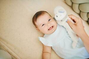 Adorable happy 6 months old baby lying in crib, play time, top view photo