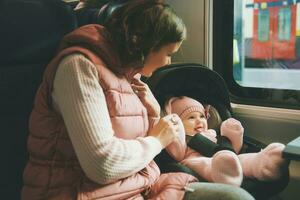Young happy mother traveling with little baby by train photo