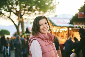 al aire libre retrato de contento joven mujer visitando Navidad mercado foto