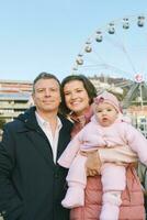 al aire libre retrato de contento familia con adorable bebé niña a Navidad mercado foto