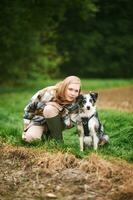 al aire libre retrato de hermosa joven mujer jugando con australiano pastor perro foto