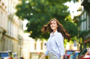 Fashion portrait of beautiful young woman, wearing blue shirt, posing outdoors photo