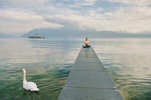 al aire libre retrato de joven hermosa mujer practicando yoga por el lago foto