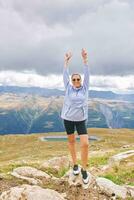 Outdoor portrait of happy young woman hiking in autumn mountains photo