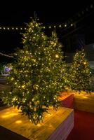 Christmas tree in pot with red decorations and lights outdoors near grey loft building photo