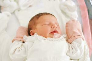 Portrait of adorable newborn baby lying in hospital crib photo