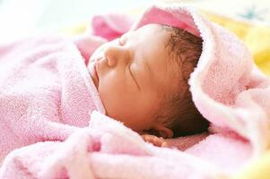 Newborn baby covered in towel after taking bath photo