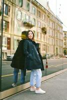 al aire libre retrato de hermosa 40 año antiguo mujer propensión en espejo muro, calle Moda foto