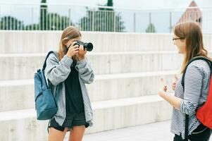 Young teenage girl taking pictures of her friend, hobby and leisure for children photo