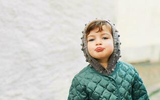 Outdoor portrait of funny toddler girl pulling a tongue photo