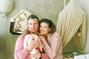 Happy family with baby, first time parents holding newborn daughter photo