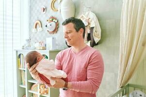 Father admiring newborn baby, dad holding tiny newborn daughter photo