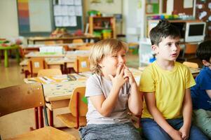 Two concentrated 4-5 year old boys in classroom, preschool children photo