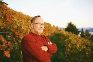 Outdoor portrait of middle age man posing in autumn vineyard photo