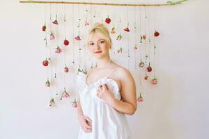 estudio retrato de bonito joven Adolescente 15 - dieciséis año antiguo niña vistiendo verano vestido, posando en blanco antecedentes con colgando rosas, participación cesta con margarita flores, belleza y Moda concepto foto