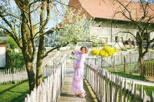 Outdoor portrait of happy pregnant woman enjoying nice sunny day in spring garden photo