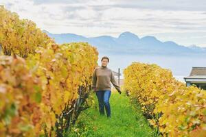 Outdoor portrait of happy laughing woman hiking in autumn vineyards, Lavaux, Switzerland photo