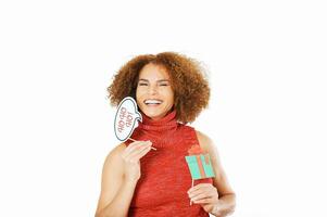 Christmas portrait of beautiful middle age woman against white background, wearing red dress, holding festive party props for photo booth