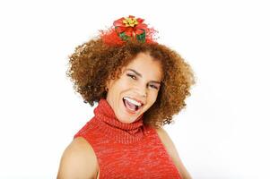 estudio retrato de contento hermosa medio años mujer Listo a celebrar Navidad y nuevo año, posando en blanco fondo, vistiendo rojo vestido, dama con Navidad regalo venda foto