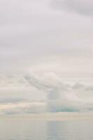 Nature background with big fluffy cloud over the lake, light pastel palette photo