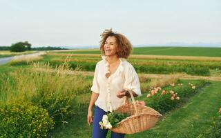 Outdoor portrait of beautiful 50 year old woman enjoying nice day in flower park or garden, happy and healthy lifestyle photo