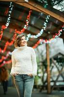 Outdoor portrait of happy young woman at Christmas market photo