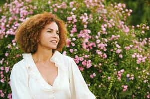 Outdoor close up portrait of beautiful middle age woman posing in garden at sunset photo