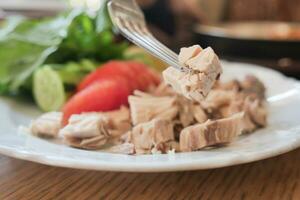 Boiled chicken breasts served with tomato on a plat photo