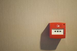 Red fire alarm button on wall , photo