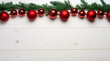 A festive garland of red globes and pine boughs on a white plane provides an ideal composition for winter and New Year celebrations. photo