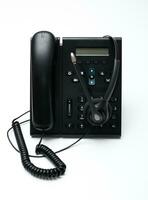 Black desktop phone with a headset on the white background photo