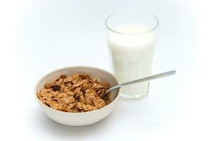 Glass of milk and bowl of brown cereals photo