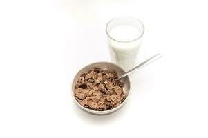 Glass of milk and bowl of brown cereals photo