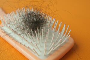 a brush with lost hair on table photo