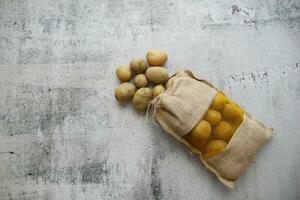 potatoes in a sack bag on table photo