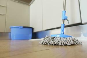 cleaning tiles floor with mop photo